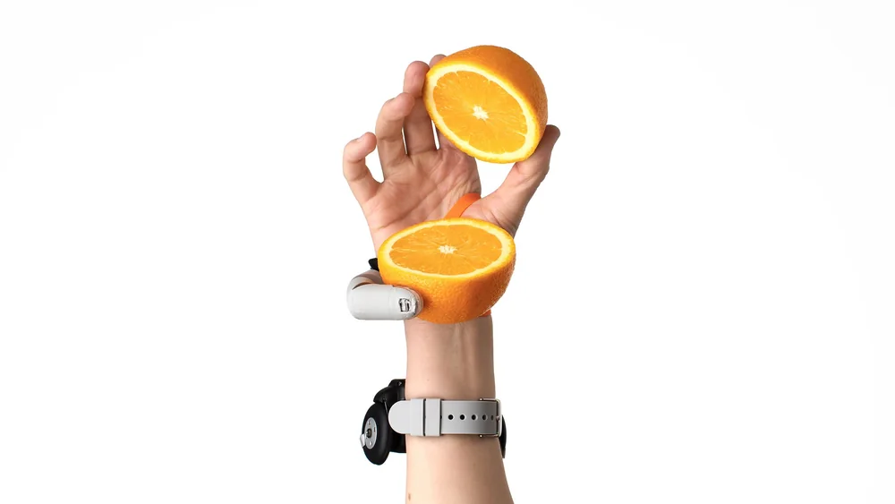 Dani Clode Third Thumb - University photograph of Dani Clode Third Thumb holding an orange.